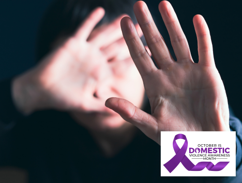 A person raising both hands toward the camera in a defensive gesture, representing domestic abuse.